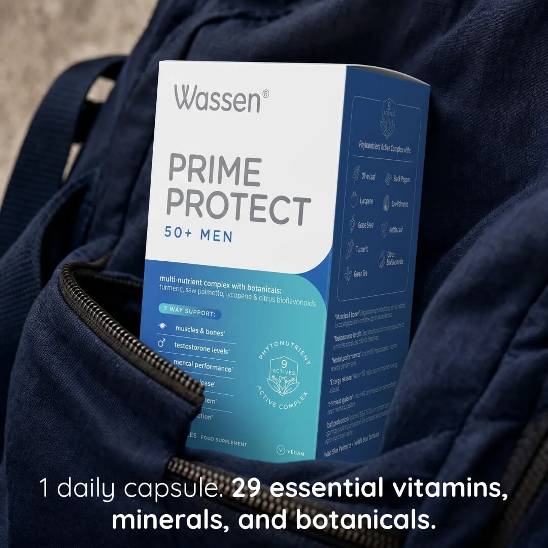A box of Wassen Prime Protect 50+ Men dietary supplement placed in a dark navy backpack, with text overlay at the bottom stating '1 daily capsule: 29 essential vitamins, minerals, and botanicals.'.