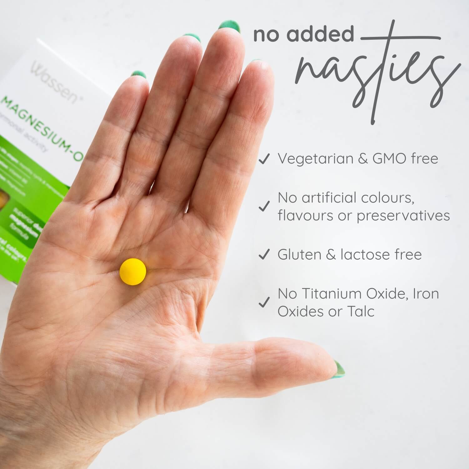 Hand holding a yellow Magnesium-OK supplement pill with product packaging in the background, featuring text about product benefits.