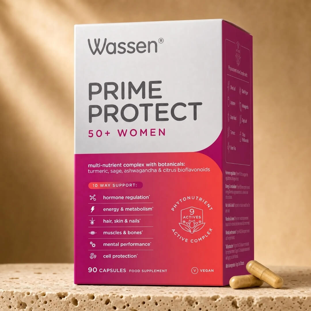 Wassen Prime Protect 50+ Women supplement box in white and magenta packaging, shown on a stone surface with two capsules in front against a warm beige background.